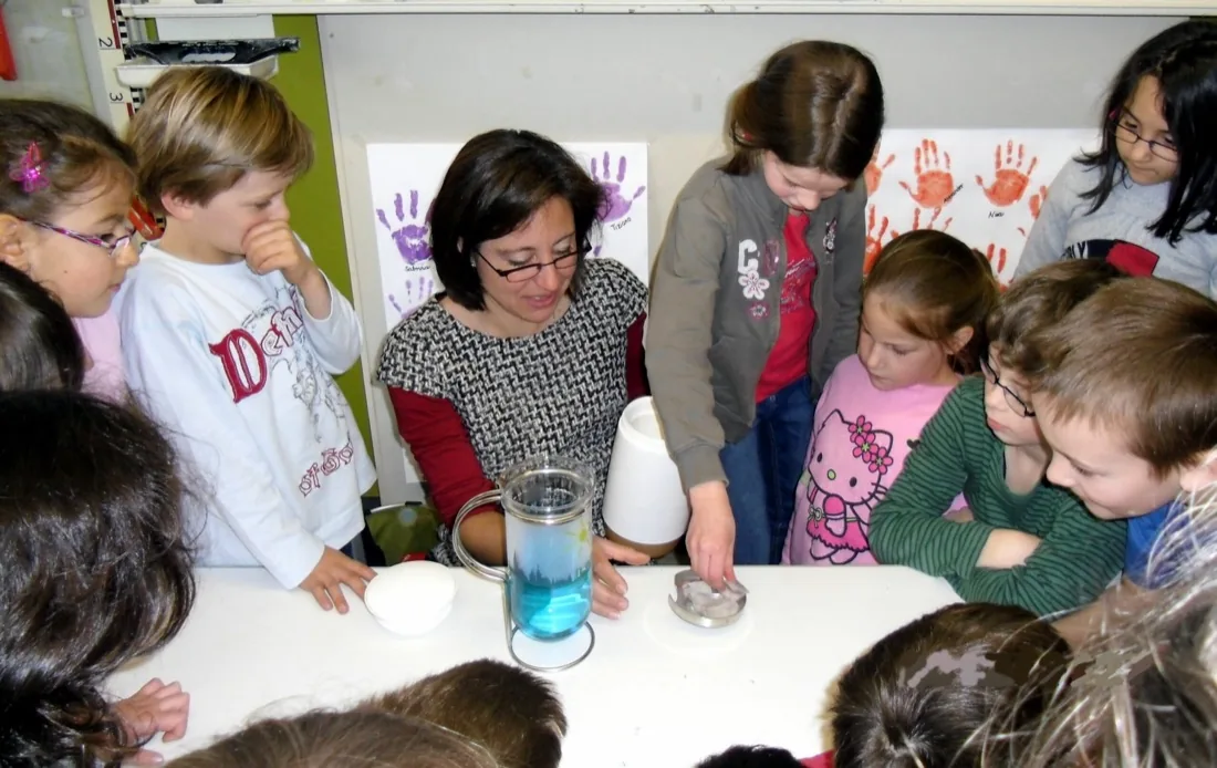 Dozentin führt mit den Kindern das Eiswürfel-Experiment durch