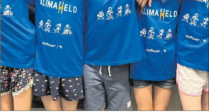 Kinder in blauen Klimahelden-T-Shirts stehen nebeneinander
